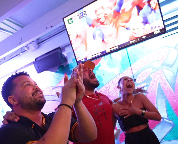 Fans cheering during the MLB World Series game at Grails Miami sports bar with 70 TVs.