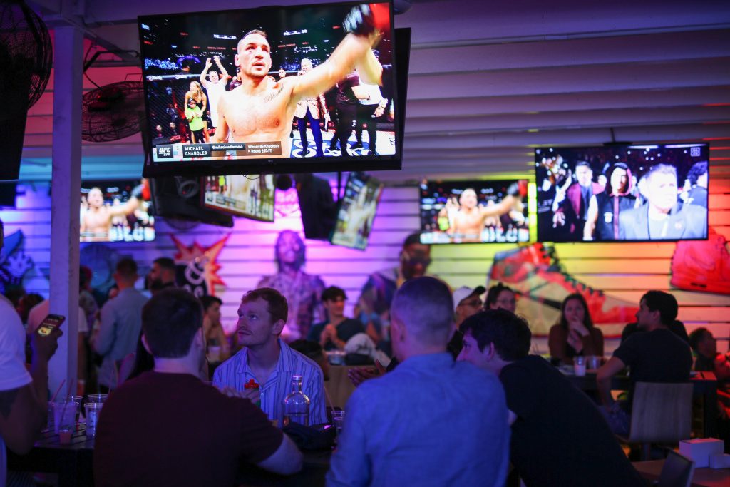 Fight fans gathered on the back patio at Grails Sports Bar in Wynwood, Miami, cheering during a major UFC match — one of the city’s best outdoor spots to watch live fights and sports events.