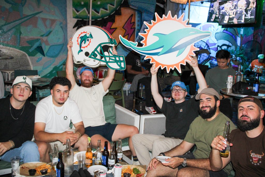 Miami Dolphins fans cheering and celebrating a touchdown at Grails Sports Bar in Wynwood — one of Miami’s best spots to watch NFL games and major sports events.